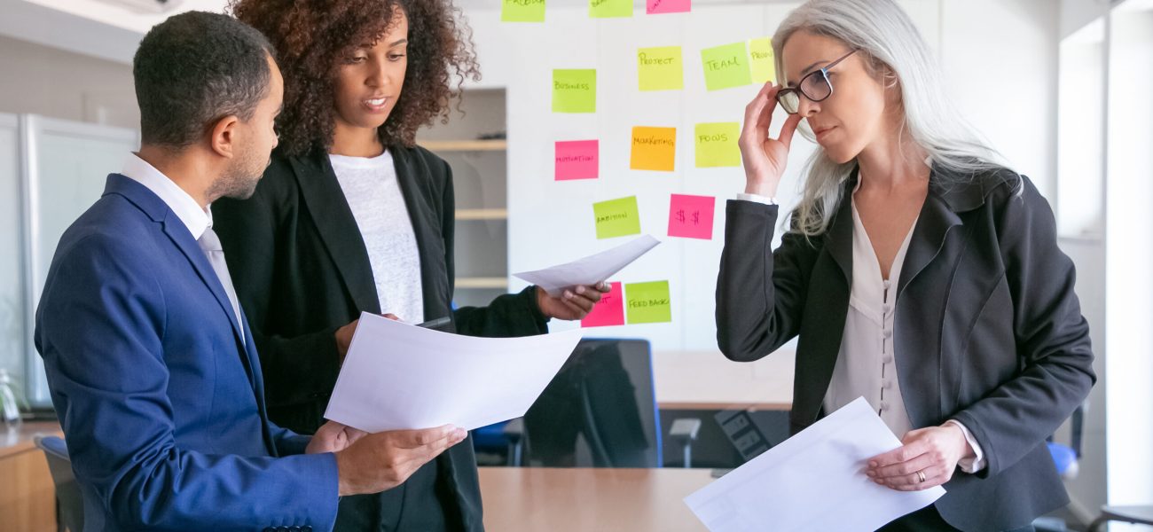 Confident businesspeople discussing analytics data. Successful experienced managers in office suits meeting in conference room and planning strategy. Teamwork, business and management concept